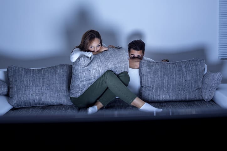 Paar versteckt sich hinter Kissen